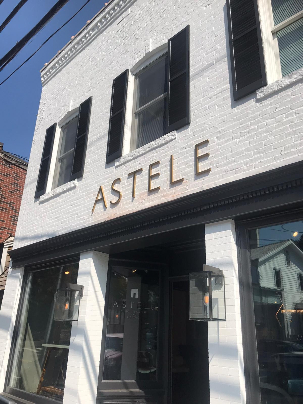Astele storefront dimensional gold letters on white brick NYC